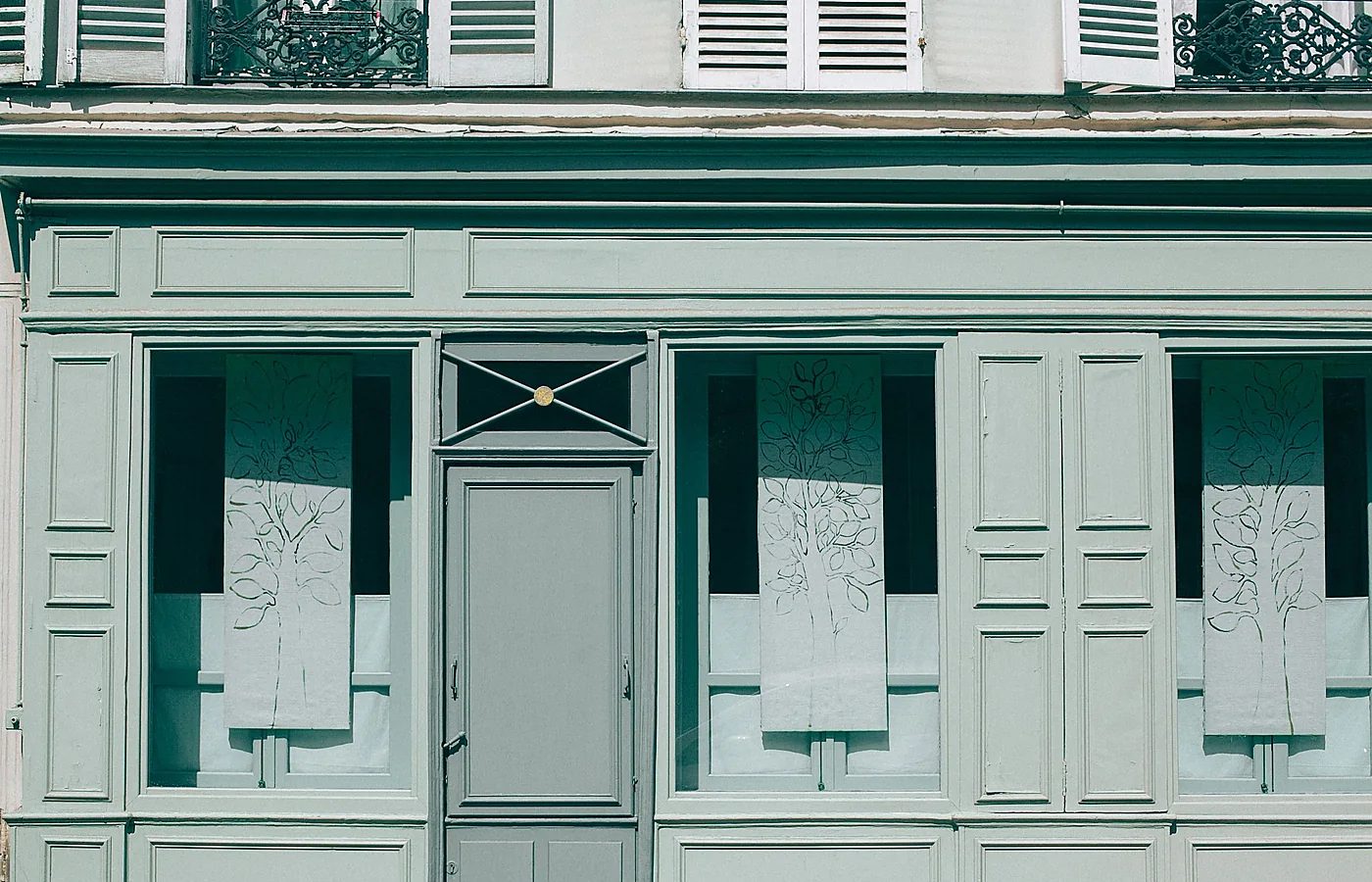 Helle ältere Hausfassade mit Fensterläden und Eingangstür